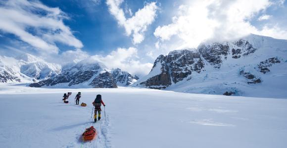 Mountaineers pulling a sled over the glacier in Alaska.