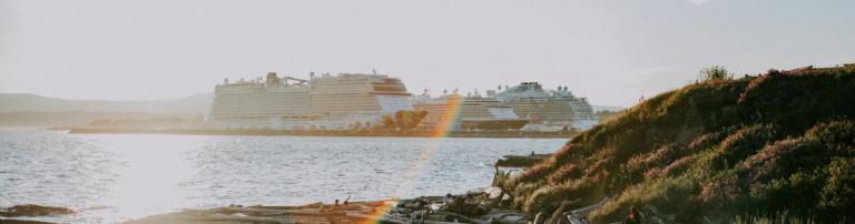 Three cruise ships docked during sunset at the Victoria port in British Columbia.