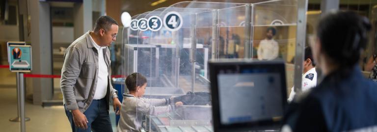 A passenger is watching their child push a bin at divesting. 