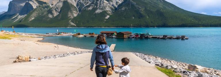Mother and son walking towards lake Minnewanka in Banff National Park