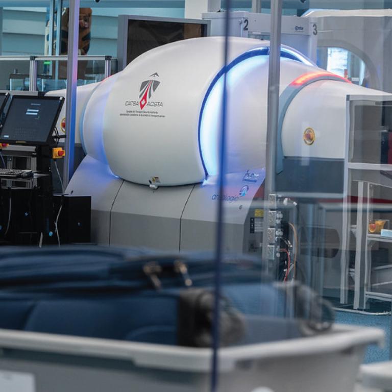 Technologie de contrôle des bagages à TDM de l'ACSTA utilisée pour contrôler les bagages de cabine à un point de contrôle de sûreté aéroportuaire.