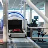 Carry-on baggage on a conveyor belt going into a CTX-ray machine. 